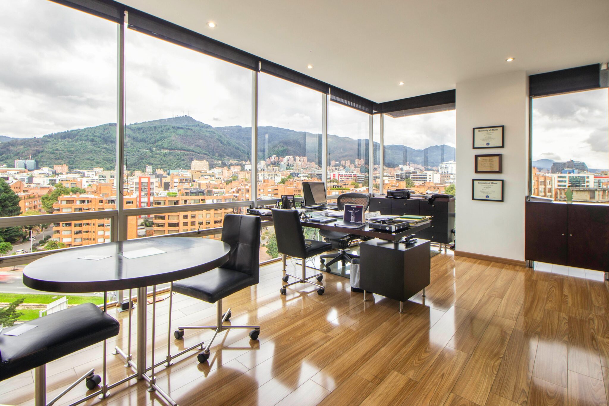 Spacious modern office with a scenic city view through glass windows.